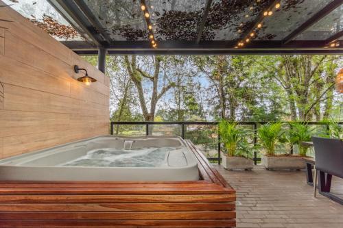 une baignoire au milieu d'un patio arboré dans l'établissement Olive Living Suites by HOUSY HOST, à Envigado