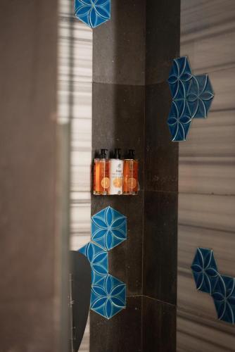 a mirror with blue tiles on a wall with candles at Hotel The Public - Special Category in Istanbul