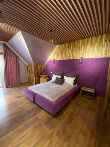 a purple bed in a room with a wooden ceiling at Four Seasons In Carpathians in Migovo