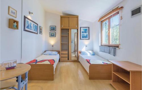 Kleines Zimmer mit 2 Betten und einem Tisch in der Unterkunft Amazing Home In Premantura With Wifi in Premantura