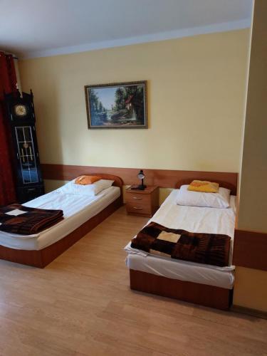 盧布林的住宿－Noclegi-Pokoje goscinne Lublin，一间卧室设有两张床,墙上挂着一个时钟。