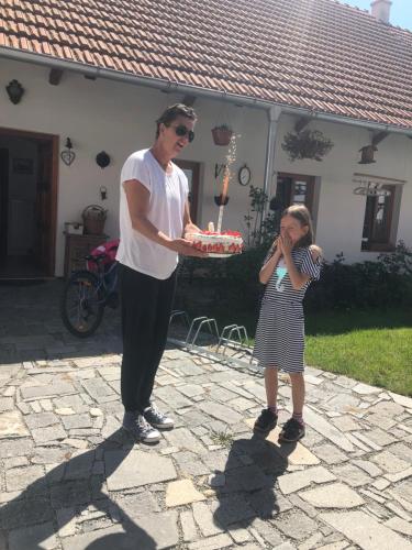 a man holding a cake with a little girl at Penzion a hospoda Na statku in Hluboká nad Vltavou