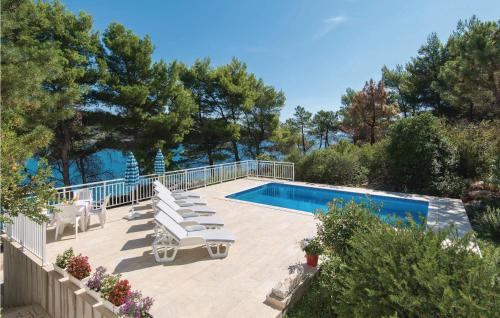 een zwembad met een groep stoelen en een zwembad bij Nice Home In Lumbarda With Outdoor Swimming Pool in Lumbarda