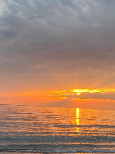 a sunset over the ocean on a beach at Dea Luxury Apartament Beach in Durrës