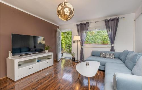 a living room with a blue couch and a tv at 2 Bedroom Awesome Apartment In Selce in Selce