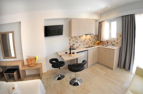 a kitchen with a table and chairs in a room at Aggelos Apartments & Deluxe Studios in Nydri