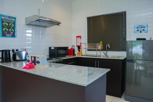 a kitchen with a counter top and a refrigerator at Hidden Valley Residence in Au Cap