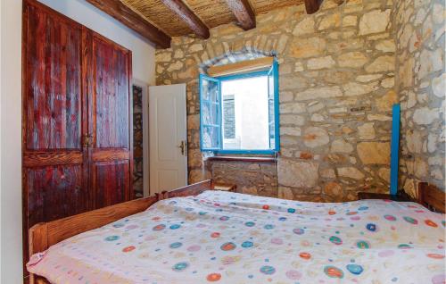 a bedroom with a bed and a stone wall at Amazing Apartment In Susak With Wifi in Susak