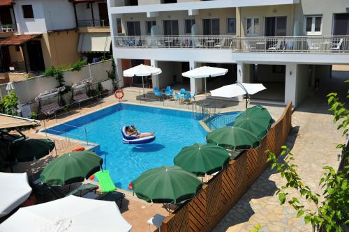 a person in a boat in a swimming pool with umbrellas at Aggelos Apartments & Deluxe Studios in Nydri