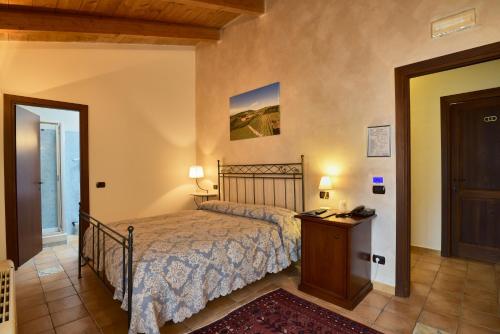 a bedroom with a bed and a table and a door at Agriturismo Podere La Piazza in Costigliole dʼAsti