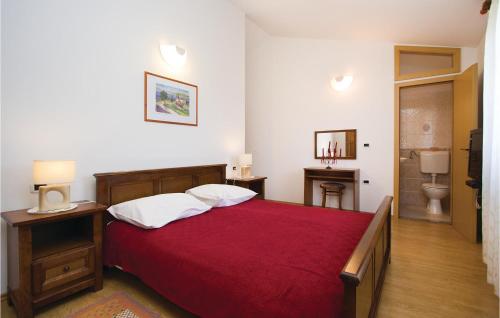 a bedroom with a red bed and a bathroom at Nice Home In Belavici With 2 Bedrooms And Wifi in Hreljići