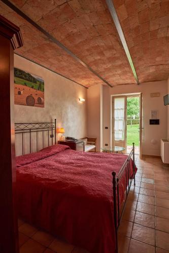a bedroom with a bed with a red bedspread at Agriturismo Podere La Piazza in Costigliole dʼAsti