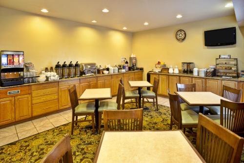 een restaurant met tafels en stoelen en een toonbank bij Country Inn & Suites by Radisson, Marion, OH in Marion