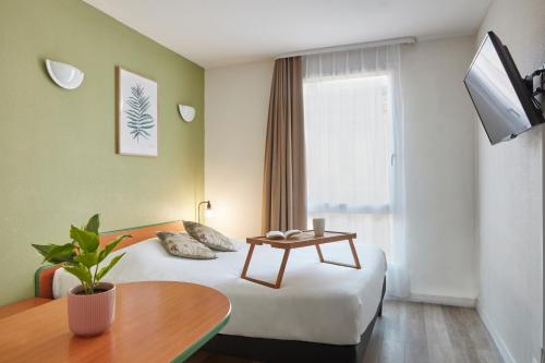 una stanza d'albergo con un letto e un tavolo di Aparthotel Adagio Access Bordeaux Rodesse a Bordeaux
