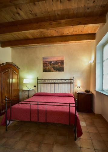 a bedroom with a bed with a red bedspread at Agriturismo Podere La Piazza in Costigliole dʼAsti