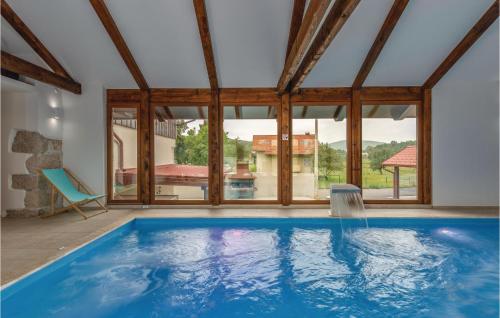 a swimming pool in a house with a large window at Stunning Home In Gospic With Sauna, Wifi And Indoor Swimming Pool in Gospić