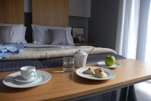 a table with two plates of food on it with a bed at B&B Habita in Modica