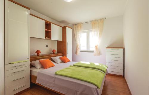 a bedroom with a bed and a dresser and a window at 2 Bedroom Lovely Apartment In Ploce in Ploče