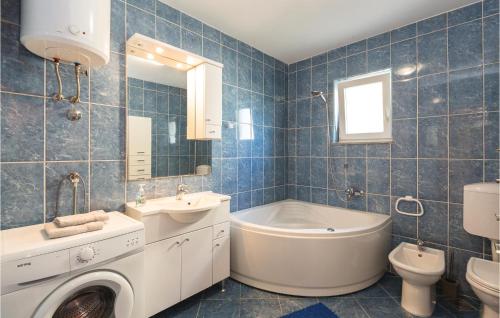 a bathroom with a tub sink and a washing machine at 2 Bedroom Lovely Apartment In Ploce in Ploče