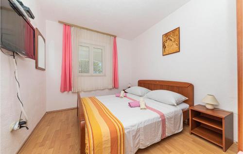 ein kleines Schlafzimmer mit einem Bett und einem TV in der Unterkunft Stunning Home In Drvenik Mali With 2 Bedrooms And Wifi in Velike Kuknjare