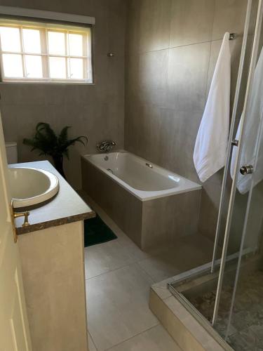 La salle de bains est pourvue d'une baignoire et d'un lavabo. dans l'établissement Marielitsa Inn, à Germiston