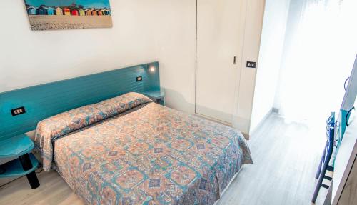 a bedroom with a bed with a blue head board at All'Orologio - Boutique Hotel in Caorle