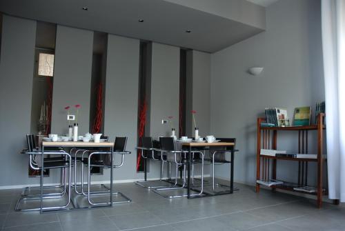 a room with tables and chairs in a room with a wall at B&B Habita in Modica