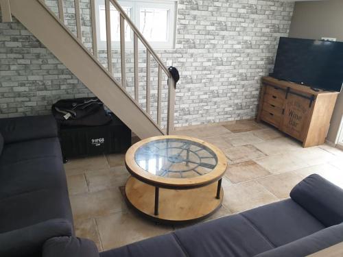 - un salon avec une table et un escalier dans l'établissement Côté Mer - Jardin privatif à 200m de la plage, à Ver-sur-Mer