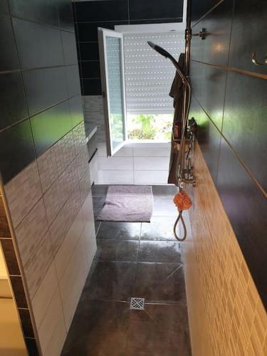 a bathroom with a walk in shower and a window at Côté Mer - Jardin privatif à 200m de la plage in Ver-sur-Mer