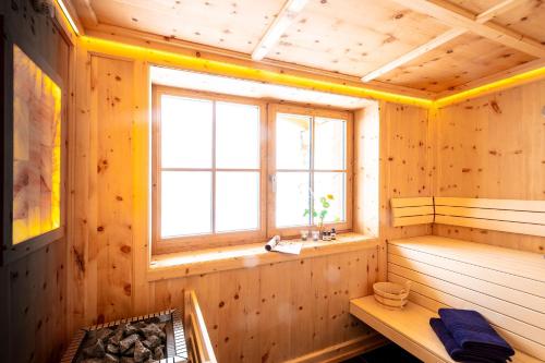 um quarto em madeira com uma sauna e uma janela em Ferienhaus Mandlberggut by globboard em Schladming