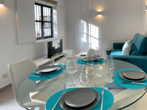 a dining room with a glass table with wine glasses at T1 center of Marina Vilamoura in Quarteira