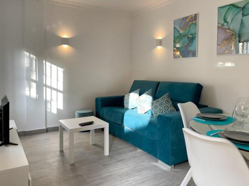 a living room with a blue couch and a table at T1 center of Marina Vilamoura in Quarteira