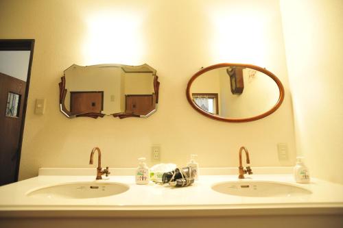 La salle de bains est pourvue de 2 lavabos et d'un miroir. dans l'établissement Nagasaki Kagamiya, à Nagasaki