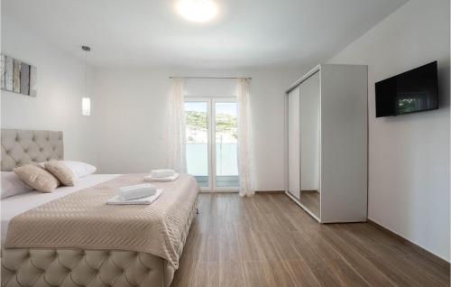 a white bedroom with a large bed and a television at Gorgeous Home In Srinjine in Srinjine