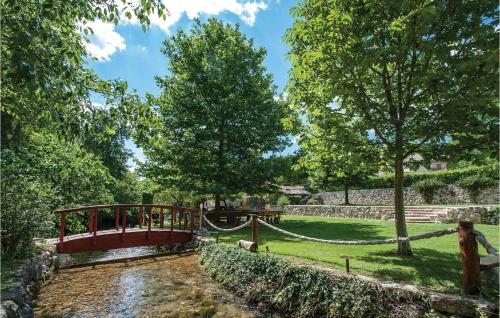 a red bridge over a stream in a park at Gorgeous Home In Srinjine in Srinjine