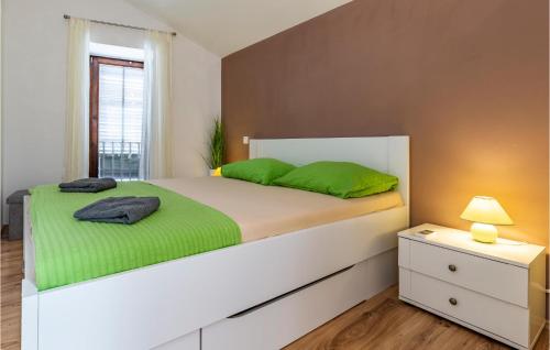 - une chambre avec un grand lit blanc et des draps verts dans l'établissement Beautiful Home In Pomer With Wifi, à Pomer