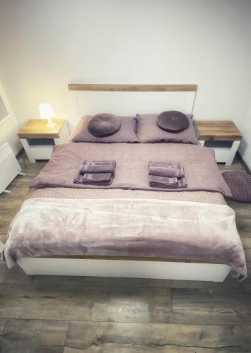 Un dormitorio con una cama grande con mantas y almohadas púrpuras. en Komfortowe Apartamenty w Kamienicach - Sercu Miasta Dusznik Zdroju en Duszniki Zdrój