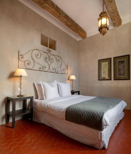 a bedroom with a large bed and two tables and a lamp at Luxurious Provencal Village House, Walk to Village Pool in Rustrel