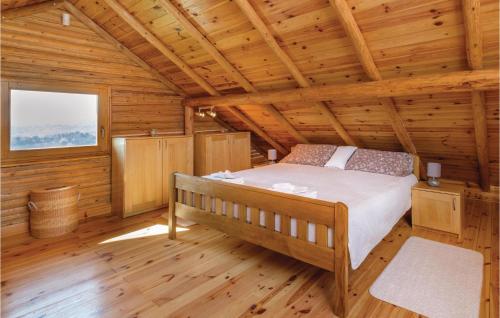 ein Schlafzimmer mit einem Bett in einem Blockhaus in der Unterkunft Cozy Home In Jastrebarsko With House A Panoramic View in Jastrebarsko