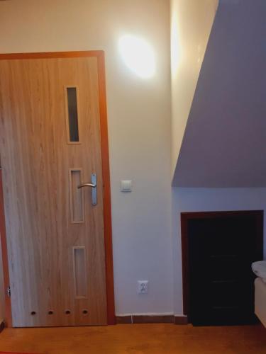 a wooden door in a room with a fireplace at Pokoje Gościnne in Gdańsk
