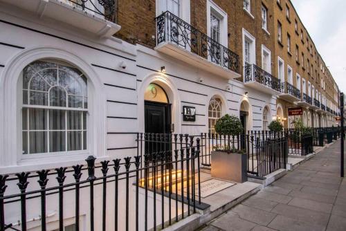 a white building with a black fence in front of it at Howard Winchester Hotel in London
