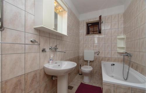 La salle de bains est pourvue d'un lavabo, de toilettes et d'une baignoire. dans l'établissement Awesome Apartment In Racisce With Kitchenette, à Račišće