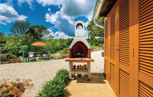 mały dom z małym piekarnikiem na dziedzińcu w obiekcie One-Bedroom Holiday Home In Bartici w mieście Barbići