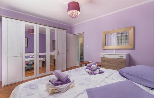 a bedroom with purple walls and a large bed at Amazing Apartment In Rabac With Wifi in Raša