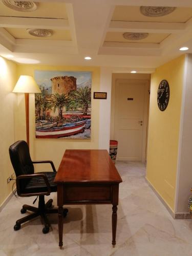 un bureau avec un bureau, une chaise et un réveil dans l'établissement Federico 70 Giada Economy, à Palerme