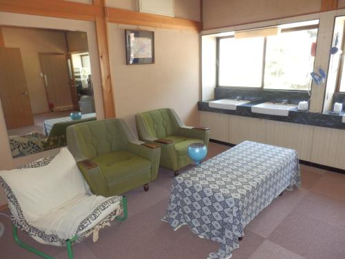 a room with two chairs and a table and a window at 富山県 よしのや旅館 in Nanto
