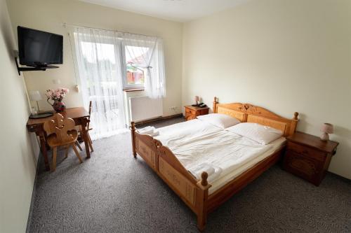 a bedroom with a bed and a desk and a television at Zajazd Chyżne in Chyżne