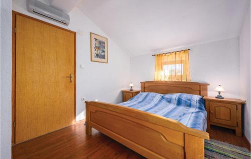 een slaapkamer met een bed en een houten deur bij 2 Bedroom Gorgeous Home In Marcenagla in Marčenigla
