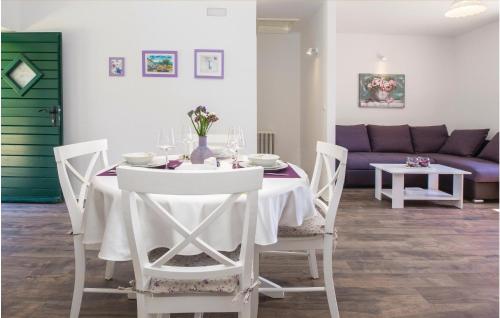 una sala da pranzo con tavolo bianco e sedie bianche di Gorgeous Home In Hrvace With Wifi a Rumin