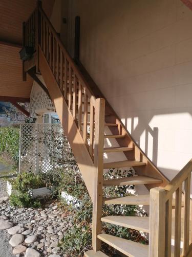 a wooden staircase in a house with a stone walkway at Nid de pie Grand duplex lumineux cadre verdoyant calme à 5 mn de la mer près Port en Bessin, Bayeux, Omaha Beach, in Commes